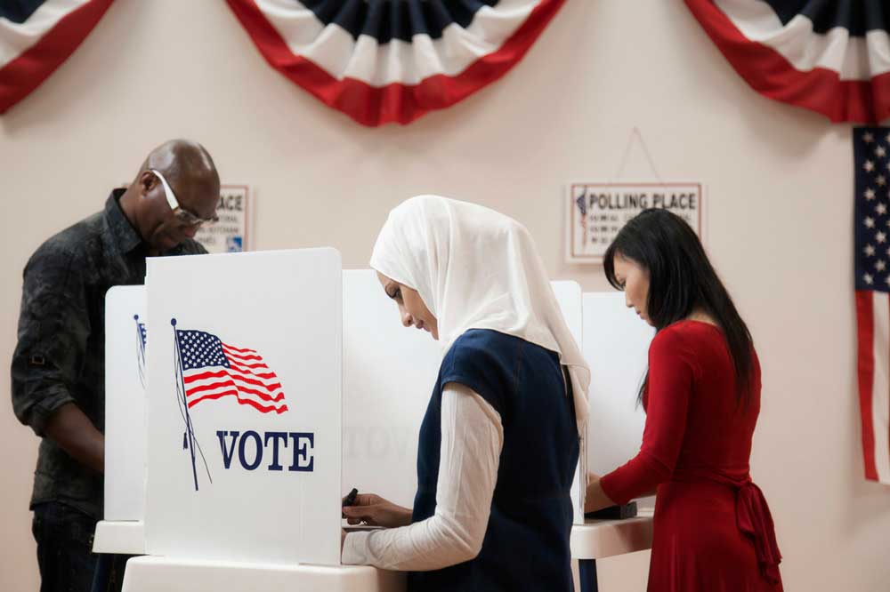 A woman wearing a white hijab at the voting booth