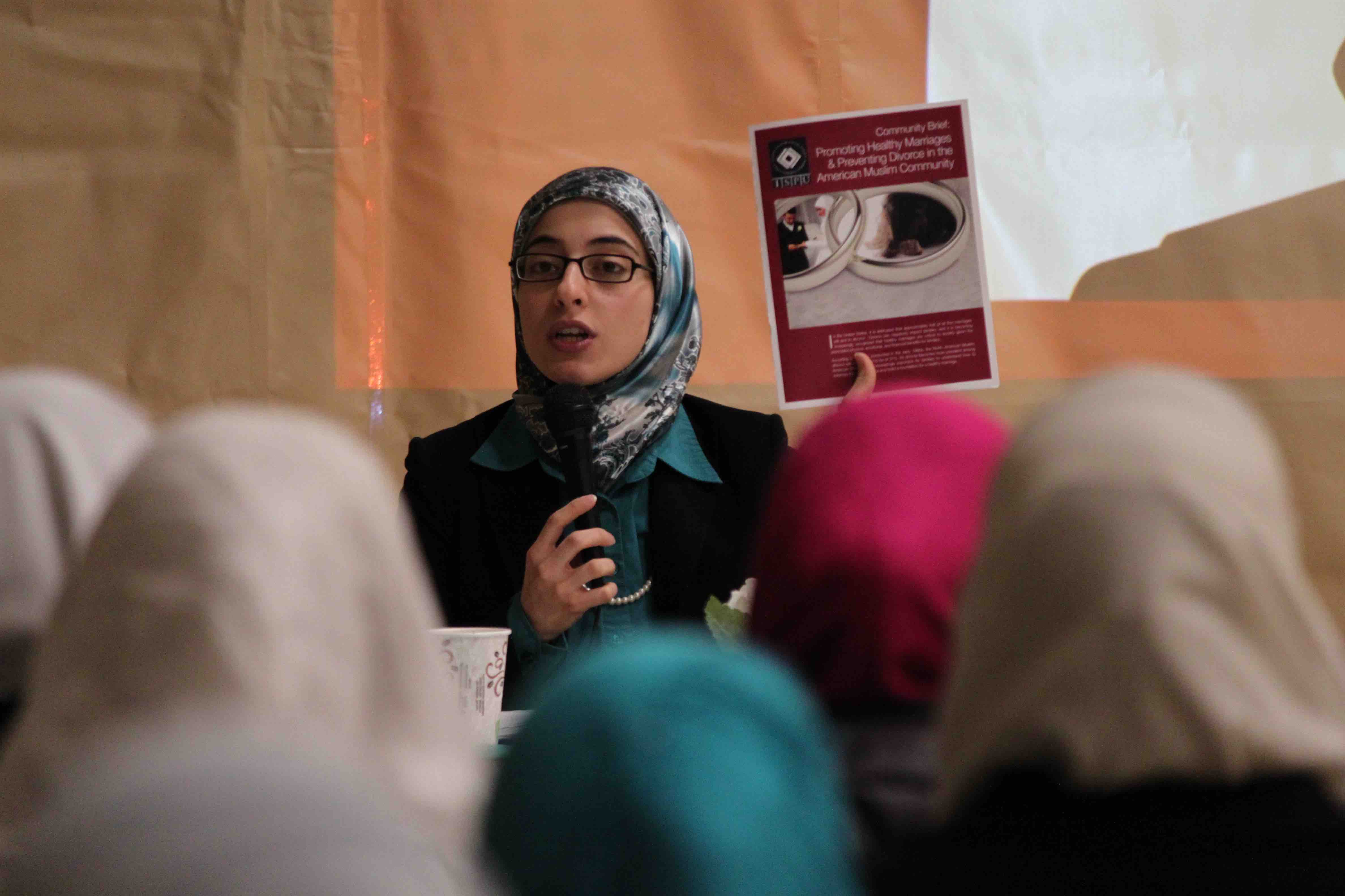 ISPU Scholar and report author Amal Killawi holding up a marriage and divorce report in front of a group of Muslim women