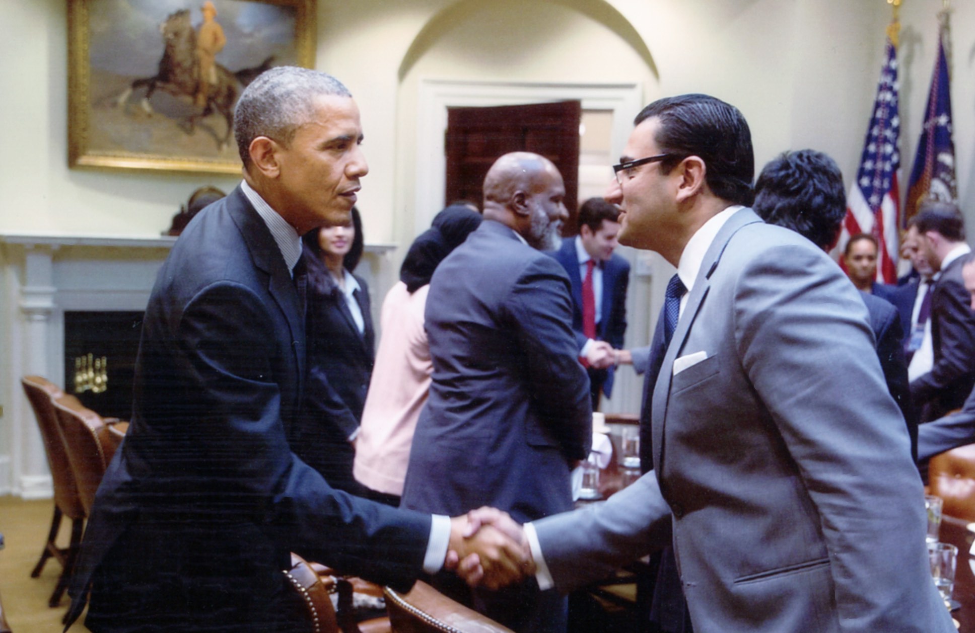 Former President Barack Obama shaking hands with Farhan Latif