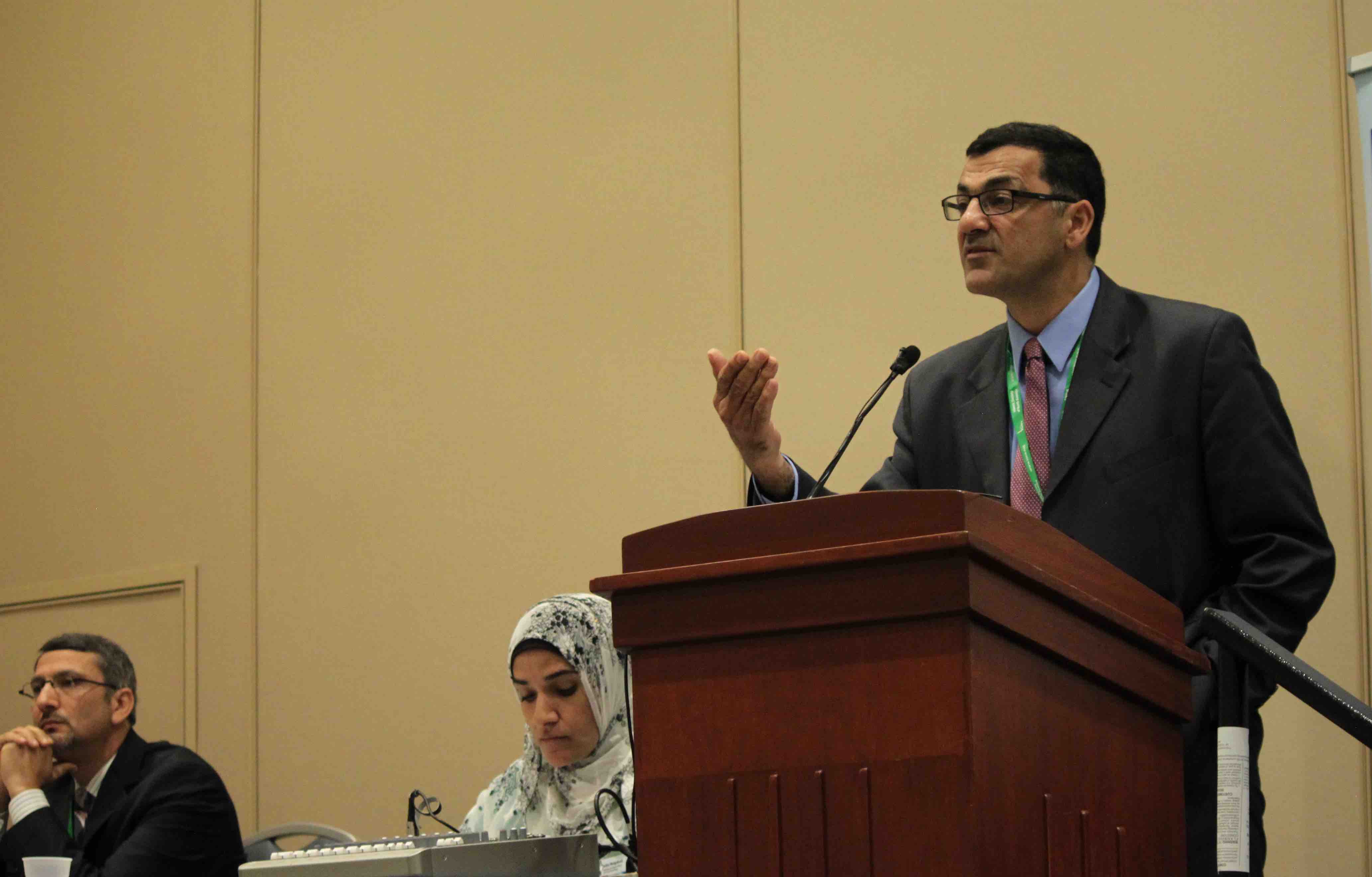 Debate participant Salam Al-Marayati at the podium explaining his perspective