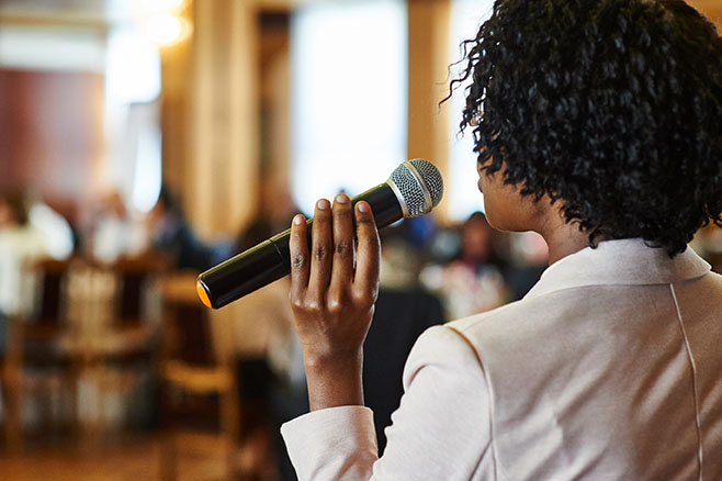 Female speaker with microphone giving presentation