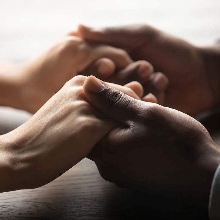 Mixed race couple holding hands on table