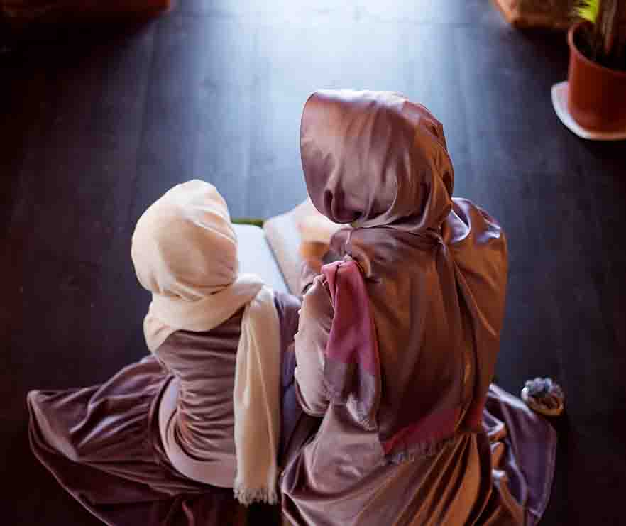 A mother and daughter reading the Quran