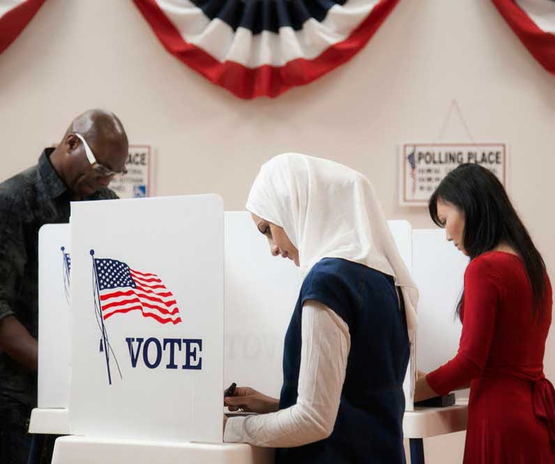 A woman wearing a white hijab at the voting booth