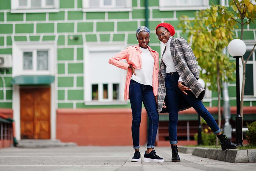 Two young, Black Muslim women posing and smiling