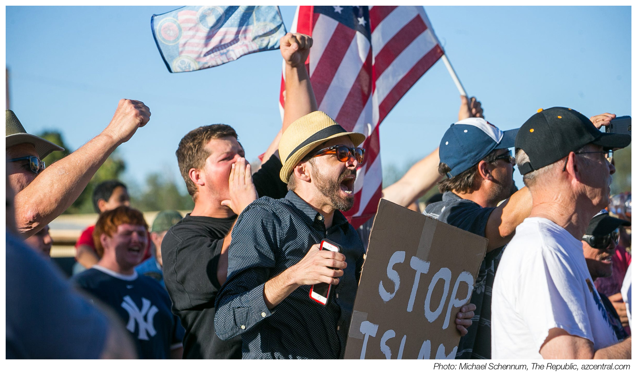 A crowd of protesting, yelling men. One carries a sign reading "stop Islam". An American flag is held in the back.