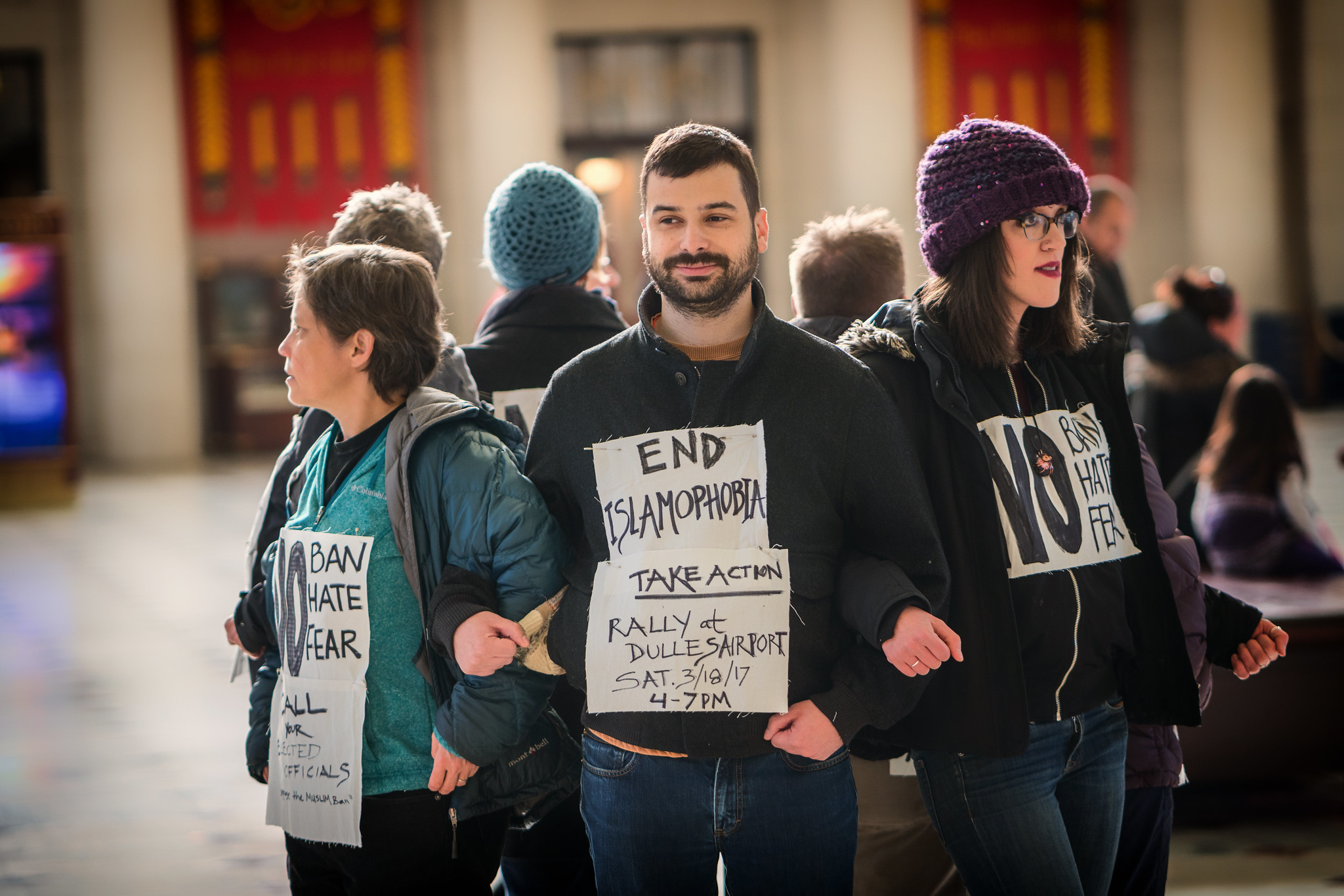Protesters link arms, wearing signs saying "End Islamophobia" at Union Station in Washington DC, photo by Lorie Shaull from Flickr.